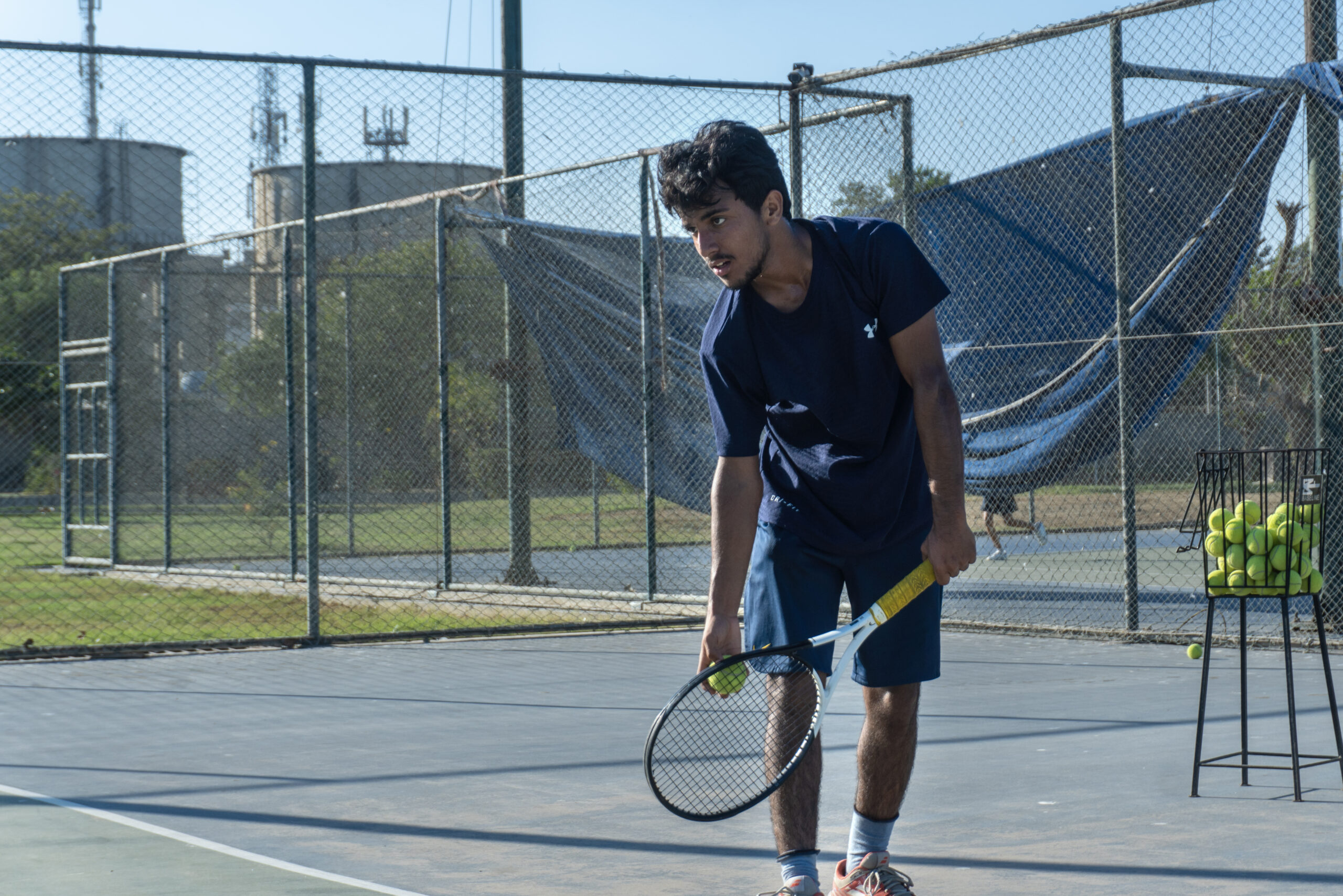Player practicing drills with a ball basket during junior tennis training at Baseline Tennis Academy, DHA, Karachi