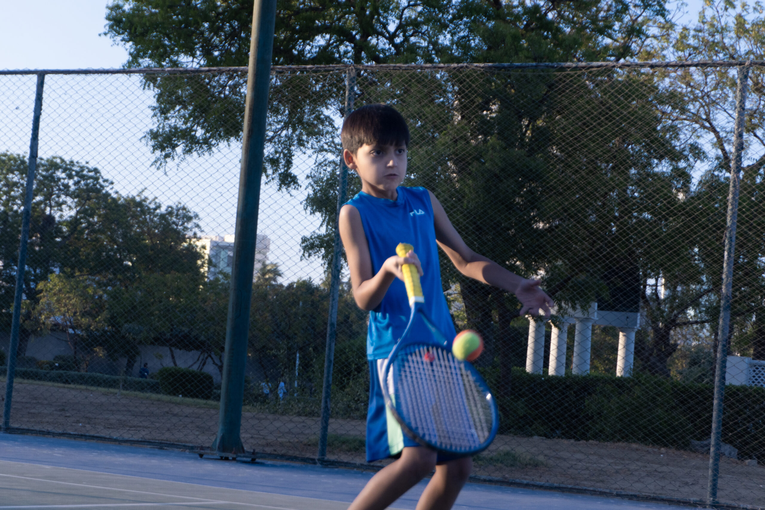 Junior player hitting a forehand during a kids tennis class at Baseline Tennis Academy, DHA, Karachi