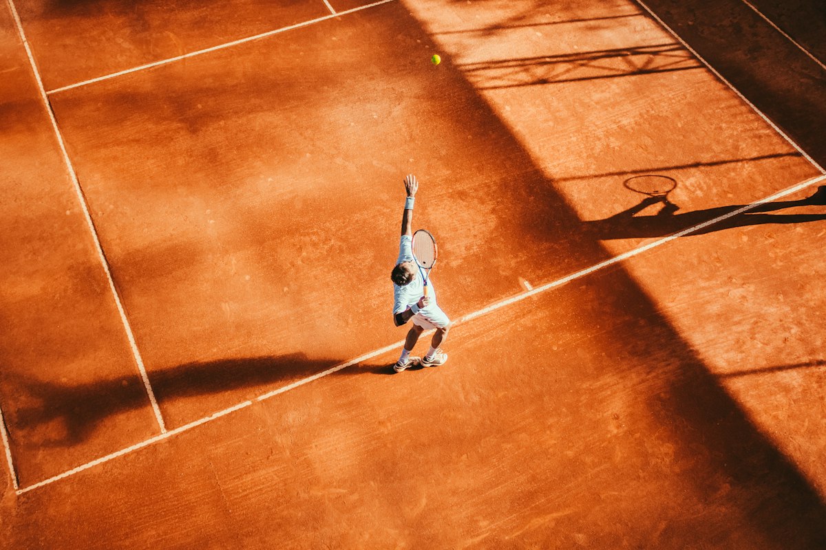 Adult beginner playing tennis on court during a lesson, illustrating adult tennis classes at Baseline Tennis Academy in DHA, Karachi